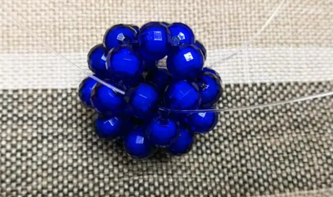 第十四步：右手線穿上兩顆珠子，并回穿與左線打結，形成如圖15的樣子